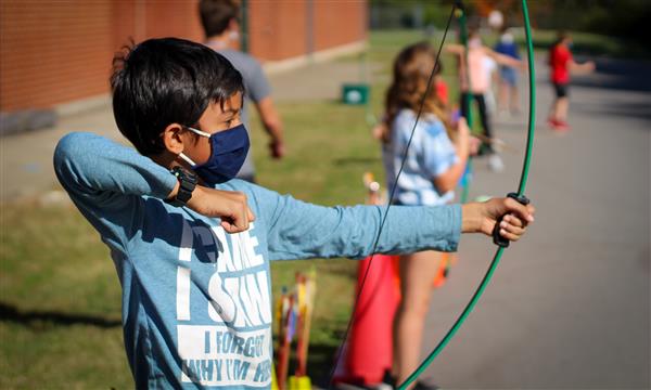 Boy gets ready to fire arrow